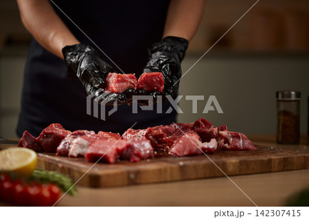 Chef hands preparing raw beef cubes for cooking Chef hands preparing raw beef cubes for cooking 142307415
