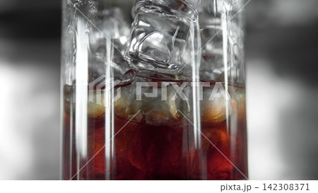 Refreshing iced drink with falling ice cubes in a close-up, illustrating coolness and refreshment on a hot day Refreshing iced drink with falling ice cubes in a close-up, illustrating coolness and refreshment on a hot day 142308371