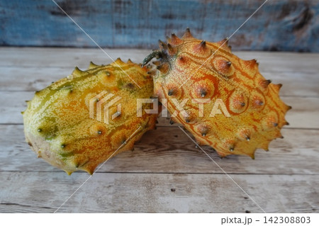 Horned melon exotic fruit on wooden background Horned melon exotic fruit on wooden background 142308803