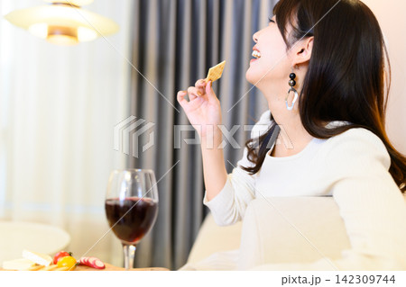 クラッカーを食べる女性、ワイングラス クラッカーを食べる女性、ワイングラス 142309744