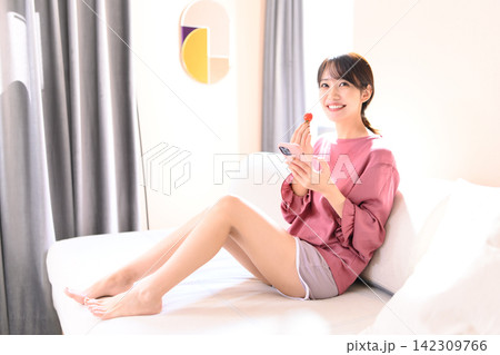 ソファでミニトマトを食べる女性 ソファでミニトマトを食べる女性 142309766