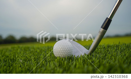 Golf clubs and balls on a green lawn in a beautiful golf course with morning sunshine. Golf clubs and balls on a green lawn in a beautiful golf course with morning sunshine. 142310368