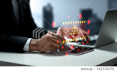 Businessman working on a laptop and tablet with a holographic virus alert and malware warning hologram floating above. Concept of Technology Security Businessman working on a laptop and tablet with a holographic virus alert and malware warning hologram floating above. Concept of Technology Security 142310370
