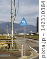 山を背景に立つ子供の横断を知らせる道路標識 142310384