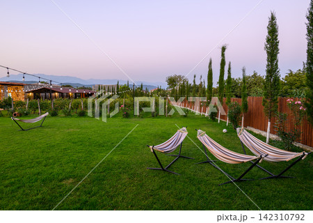 A serene outdoor scene featuring a tranquil garden area with vibrant green grass A serene outdoor scene featuring a tranquil garden area with vibrant green grass 142310792
