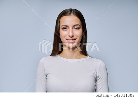 Close-up portrait of smiling young woman looking at camera studio shot Close-up portrait of smiling young woman looking at camera studio shot 142311308