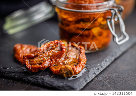 Sun-Dried Tomatoes in Jar With Olive Oil Preserved Gourmet Mediterranean Antipasto Close-Up Sun-Dried Tomatoes in Jar With Olive Oil Preserved Gourmet Mediterranean Antipasto Close-Up 142311504
