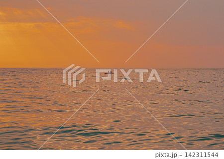 Distant view of couple on stand up paddleboard SUP in calm sea waters during golden warm sunset in Lefkada island Greece horizontal stock photo Distant view of couple on stand up paddleboard SUP in calm sea waters during golden warm sunset in Lefkada island Greece horizontal stock photo 142311544