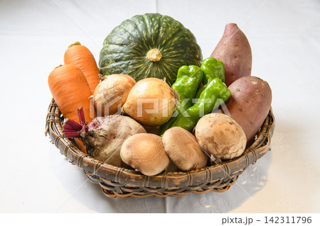 かごに盛られた新鮮な野菜の詰め合わせ、カラフルな農産物の美しい調和 かごに盛られた新鮮な野菜の詰め合わせ、カラフルな農産物の美しい調和 142311796