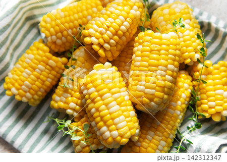 Fresh sweet corn cobs on striped cloth 142312347