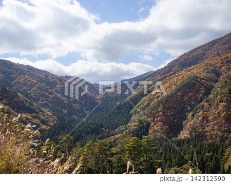 青空と白い雲が広がる秋の山並みと紅葉 青空と白い雲が広がる秋の山並みと紅葉 142312590