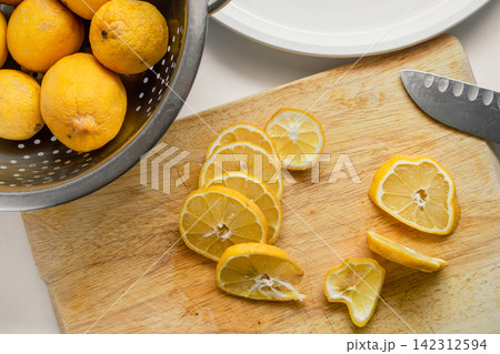 Fresh Garden Lemons Sliced for Drying on a Wooden Cutting Board Fresh Garden Lemons Sliced for Drying on a Wooden Cutting Board 142312594