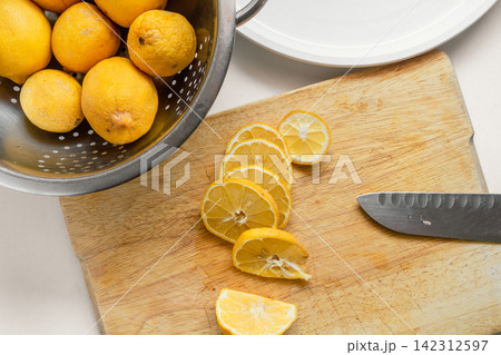 Fresh Garden Lemons Sliced for Drying on a Wooden Cutting Board Fresh Garden Lemons Sliced for Drying on a Wooden Cutting Board 142312597