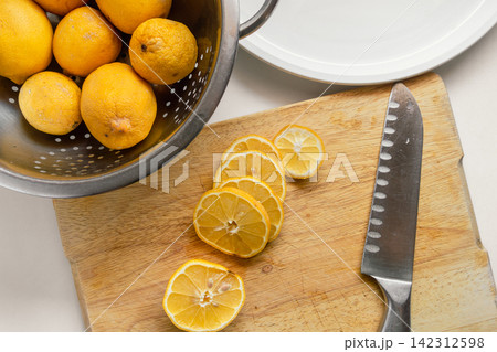 Fresh Garden Lemons Sliced for Drying on a Wooden Cutting Board Fresh Garden Lemons Sliced for Drying on a Wooden Cutting Board 142312598