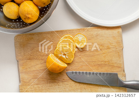 Fresh Garden Lemons Sliced for Drying on a Wooden Cutting Board Fresh Garden Lemons Sliced for Drying on a Wooden Cutting Board 142312657