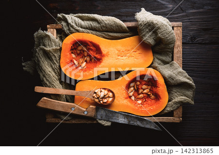 Top-down view of butternut squash halves with pumpkin seeds Top-down view of butternut squash halves with pumpkin seeds 142313865