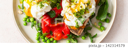 Plates of gluten free bread sandwiches filled with zucchini caviar and topped with poached eggs. Served with roasted red peppers, green peas, and spinach for breakfast, banner Plates of gluten free bread sandwiches filled with zucchini caviar and topped with poached eggs. Served with roasted red peppers, green peas, and spinach for breakfast, banner 142314579