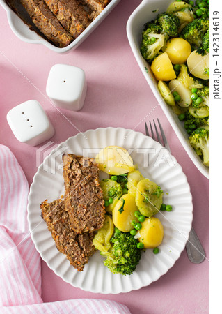 A plate holds boiled potatoes, turkey meat pie, broccoli, and green peas. This breakfast is healthy and gluten free, perfect for a good start to the day A plate holds boiled potatoes, turkey meat pie, broccoli, and green peas. This breakfast is healthy and gluten free, perfect for a good start to the day 142314619