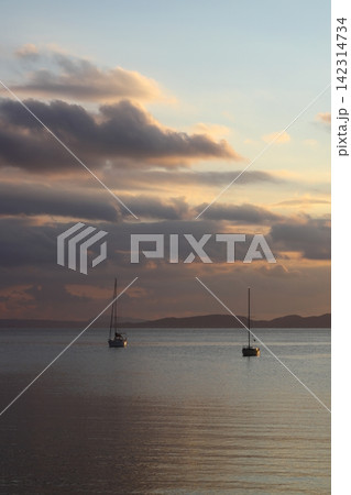 Alone sailboats at sunset. Atmospheric seascape with reflection Alone sailboats at sunset. Atmospheric seascape with reflection 142314734