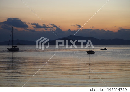 Alone sailboats at sunset. Atmospheric seascape with reflection Alone sailboats at sunset. Atmospheric seascape with reflection 142314739