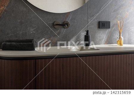 Integrated bathroom basin featuring folded towels in gentle window illumination Integrated bathroom basin featuring folded towels in gentle window illumination 142315659