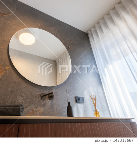 Large round bathroom mirror above a floating vanity with clear geometry Large round bathroom mirror above a floating vanity with clear geometry 142315667