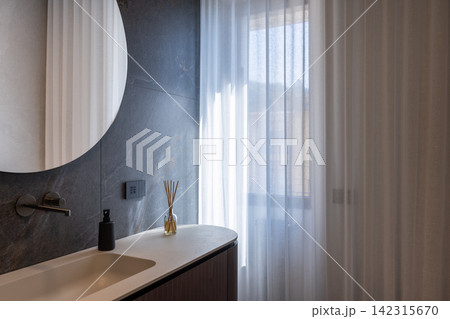 Bathroom vanity featuring sheer curtain in softly filtered window light Bathroom vanity featuring sheer curtain in softly filtered window light 142315670