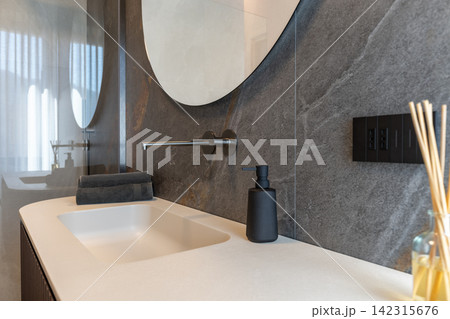Bathroom vanity with soap dispenser and reed diffuser under soft light Bathroom vanity with soap dispenser and reed diffuser under soft light 142315676