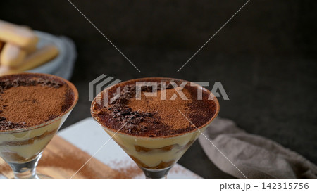 Two Glasses of Tiramisu Topped with Cocoa Powder and Shaved Chocolate Two Glasses of Tiramisu Topped with Cocoa Powder and Shaved Chocolate 142315756