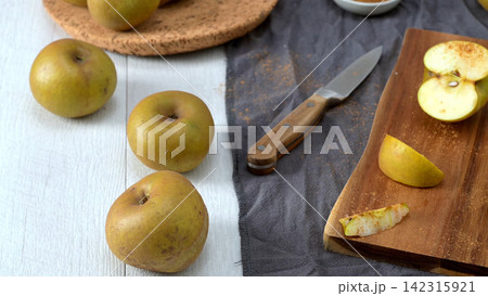 Golden Apples and Cinnamon on a Rustic Table Golden Apples and Cinnamon on a Rustic Table 142315921