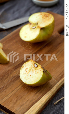 Sliced Apple with Cinnamon on a Cutting Board Sliced Apple with Cinnamon on a Cutting Board 142315922