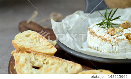 Baked Brie Cheese with Walnuts and Rosemary Served with Toasted Bread Baked Brie Cheese with Walnuts and Rosemary Served with Toasted Bread 142315963