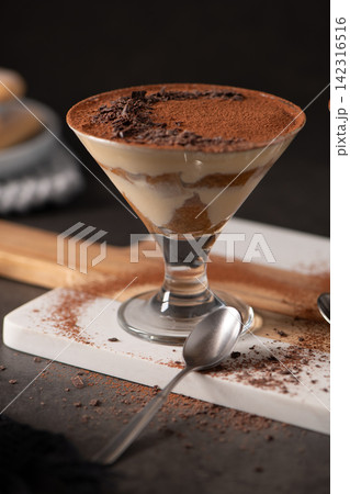 Individual Tiramisu Dessert in stemmed cocktail Glass with Cocoa Powder and Chocolate Shavings Individual Tiramisu Dessert in stemmed cocktail Glass with Cocoa Powder and Chocolate Shavings 142316516