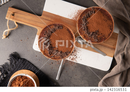 Top View of Two Tiramisu Desserts Dusted with Cocoa Powder and Chocolate Shavings 142316531
