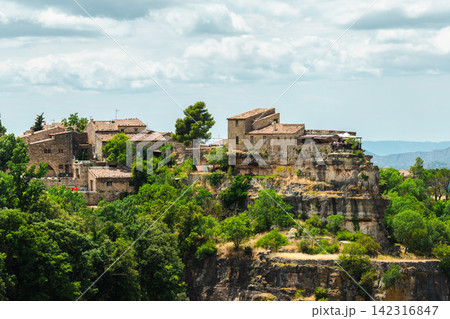 Stone buildings of Siurana village perched on rocky cliffs above forested valleys, iconic medieval settlement in Tarragona province Catalonia Spain Stone buildings of Siurana village perched on rocky cliffs above forested valleys, iconic medieval settlement in Tarragona province Catalonia Spain 142316847