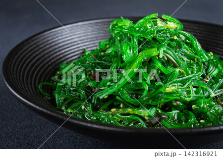 Chuka salad, made from fresh seaweed, with sesame dressing, served in a black bowl, Chuka salad, made from fresh seaweed, with sesame dressing, served in a black bowl, 142316921
