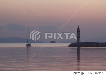 Seascape at sunshine. Lighthouse and sailings on the coast. Seaside town of Turgutreis and spectacular sunshine 142316944