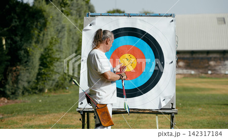 Mature man reaching goals practicing outdoor archery sport 142317184