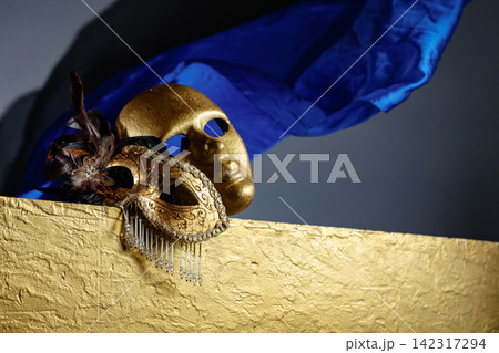 Golden carnival masks on a gold background. 142317294