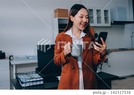 Female secretary who works in the office is talking on the phone with someone. Female secretary who works in the office is talking on the phone with someone. 142317338