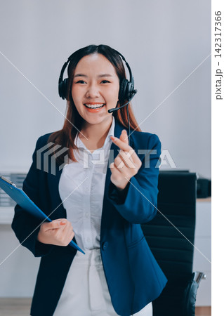 Smiling Asian Woman Telemarketing Agent with Headset Working at Smiling Asian Woman Telemarketing Agent with Headset Working at 142317366