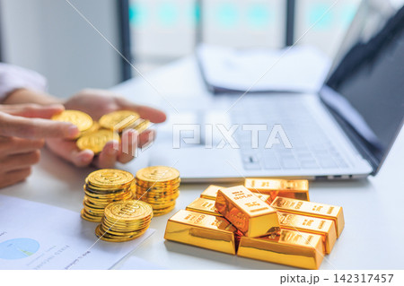 Investor, Businessman or Banker Hands Stacking Counting Gold Coins and Bullion Bars on Desk. Concept for Wealth Management and Asset Allocation with Physical Gold. 142317457