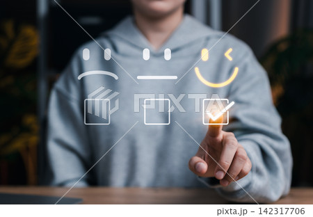 Customer satisfaction and feedback rating concept with user selecting happy face icon on digital interface, representing user experience, service quality, review system, and emotional engagement. Customer satisfaction and feedback rating concept with user selecting happy face icon on digital interface, representing user experience, service quality, review system, and emotional engagement. 142317706