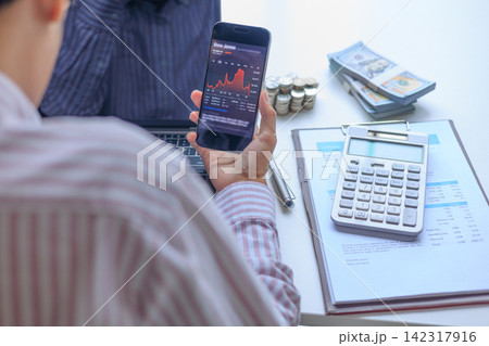 Stressed Investor Looking at Market Crash Stock Chart on Phone in Office. Stressed Investor Looking at Market Crash Stock Chart on Phone in Office. 142317916