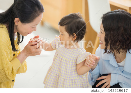 1歳の女の子を抱っこするお母さんと祖母 1歳の女の子を抱っこするお母さんと祖母 142319617