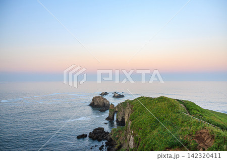 北海道浜中町・夕暮れ時の優しい光に照らされた霧多布岬のダイナミックな海岸線と岩礁地帯 142320411