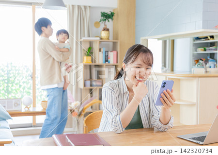 育児についてスマホで検索する母親 育児についてスマホで検索する母親 142320734