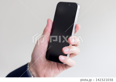 手に持ったスマートフォンのクローズアップと黒い画面のモバイルイメージ 手に持ったスマートフォンのクローズアップと黒い画面のモバイルイメージ 142321038