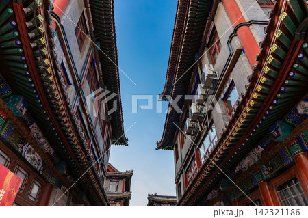 classical Chinese wooden architectural building with traditional tile roof under blue sky classical Chinese wooden architectural building with traditional tile roof under blue sky 142321186