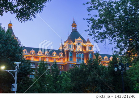 european style architectural building framed by trees in Tianjin city at dusk 142321240